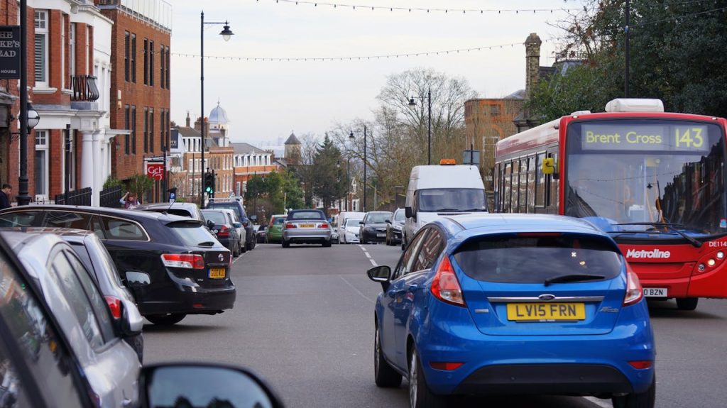 View of a busy urban street in Brent Cross featuring cars and a red bus, showcasing urban transport.